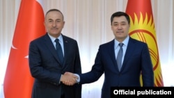 Turkish Foreign Minister Mevlut Cavusoglu (left) shakes hands with Kyrgyz President Sadyr Japarov at their meeting in Bishkek on March 10.