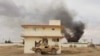 FILE: Smoke billows from a building after a Taliban attack in the rural Gereshk district of Helmand Province in March 2016.