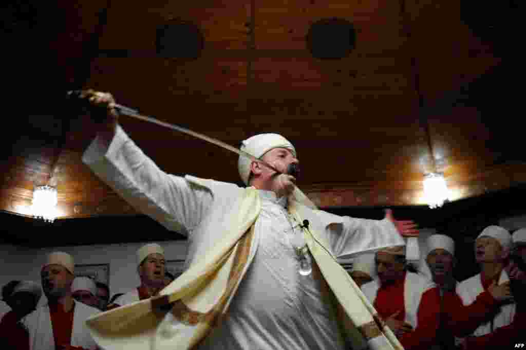 Kosovar dervishes, adepts of Sufism, a mystical form of Islam that preaches tolerance and a search for understanding, take part in a ceremony in the prayer room in the town of Gjakova. (AFP/Armend Nimani)