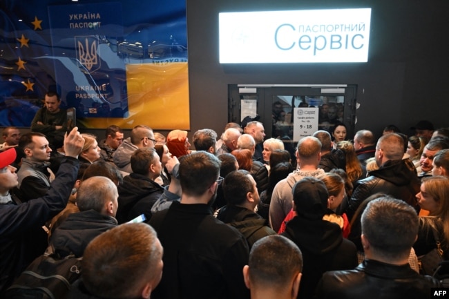 Українці зібралися перед закритим пунктом видачі паспортів України в торговому центрі у Варшаві, Польща, 24 квітня 2024 року.