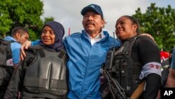 Daniel Ortega nicaraguai elnök rendőrök körében 2018. július 13-án