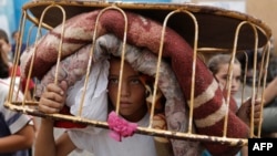 یک کودک آواره غزه در حال ترک مدرسه-پناهگاه سازمان ملل متحد در آن باریکه