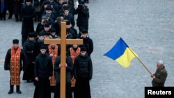 Orthodox priests and others take part in a procession commemorating the third anniversary of Ukraine's pro-European Union (EU) mass protests in central Kyiv.