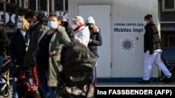 Un angajat din sănătate trece pe lângă un centru mobil de vaccinare din orașul Duisburg, vestul Germaniei, pe 12 noiembrie 2021. Țara se confruntă cu un nou val de infecții de la începutul pandemiei.