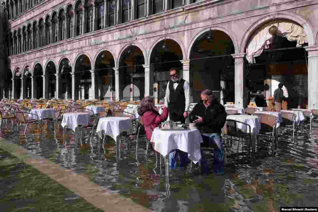 A kávézó vendégeit nem zavarja, hogy újból elöntötte a víz a Szent Márk teret Velencében november 5-én