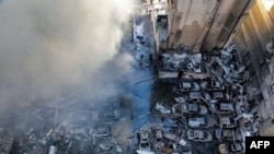 Израильдің шабуылынан кейін Бейруттың әл-Мазраа ауданында шыққан өртті сөндіріп жатқан адамдар. Ливавн, 8 сәуір, 2026 жыл.