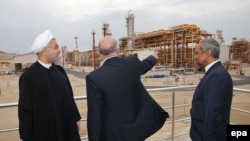 Iranian President Hassan Rohani (left) and Iranian Oil Minister Bijan Namdar Zangeneh (center) attend the inauguration of a new gas phase at the South Pars gas field near the southern Iranian port of Assalouyeh on March 17. Iran has likely lost billions in revenue from oil and natural gas due to sanctions over the last few years.