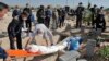 The body of a person who died from COVID-19 is interred as mourners look on at the Behesht-e-Zahra cemetery on the outskirts of Tehran on November 1.