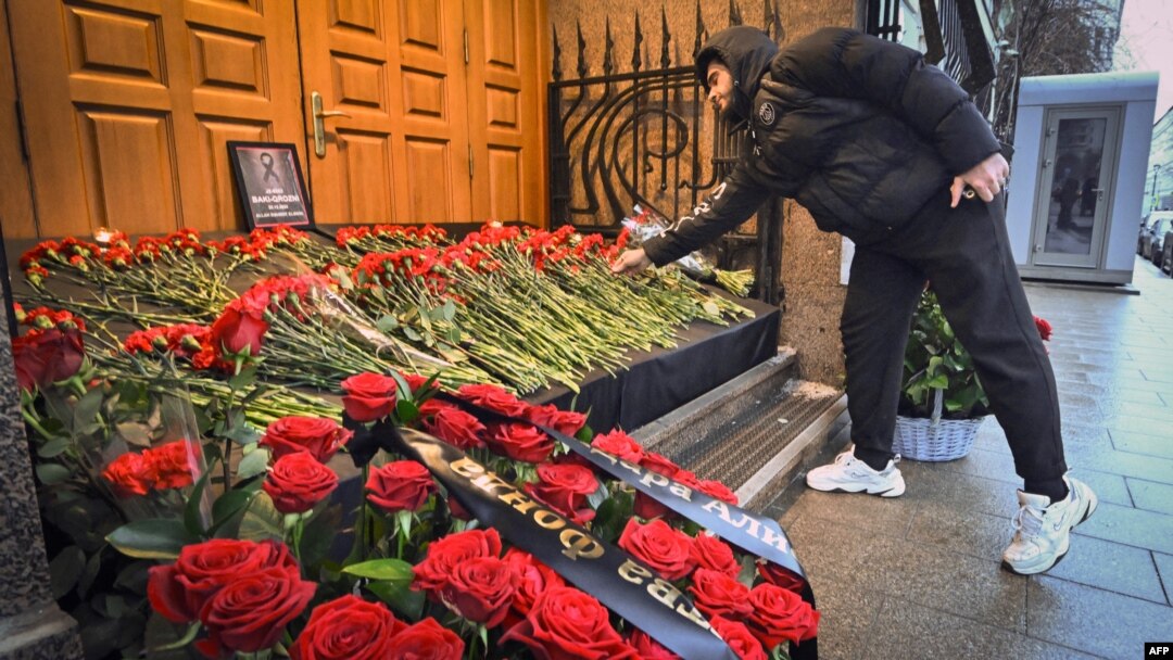 A man lays flowers to Azerbaijan's Embassy in Moscow paying tribute to the victims of an Azerbaijan Airlines' plane crash.