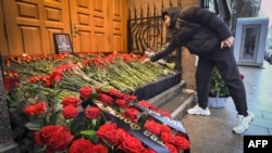 A man lays flowers at Azerbaijan's Embassy in Moscow on December 26, paying tribute to the victims of an Azerbaijan Airlines plane crash in Kazakhstan which killed dozens of people.