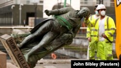 Велика Британія. Працівники знімають статую Роберта Мілігана поруч із музеєм Доклендса в Лондоні, 9 червня 2020 року