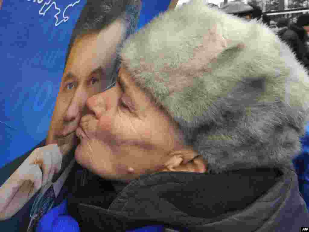 A Viktor Yanukovych supporter kisses his portrait during a rally in Kyiv.