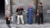 Syria -- A Syrian rebel carries a homemade explosive device as others stand back to let him pass during clashes with government troops in the Salhin district of the northern city of Aleppo on 31Jul2012