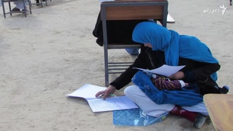 افغانه ښځه، په غېږ کې ماشوم او په لاس کې قلم