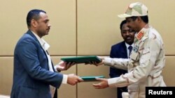 محمد حمدان داگالو، معاون رئیس شورای انتقالی نظامیان، و احمد ربیع، رهبر اپوزیسیون سودان، پس از امضای توافق‌نامه