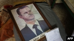 A portrait of Syrian President Bashar al-Assad is pictured with its frame broken, in a Syrian regime's Political Security Branch facility on the outskirts of the central city of Hama, following the capture of the area by anti-government forces.