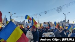 Participanții la protest au steaguri tricolore și pancarte sau sunt îmbrăcați în costume populare