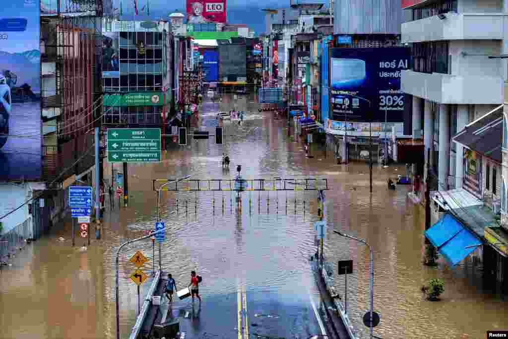 Në këtë pamje me dron shihen disa njerëz duke ecur në një rajon të vërshuar nga reshjet në Songhla të Tajlandës. Fotografi e 23 nëntorit 2025.