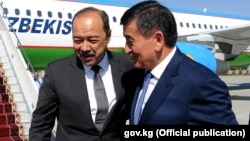 Uzbek Prime Minister Abdulla Aripov (left) is greeted by Kyrgyz Prime Minister Sooronbai Jeenbekov at Manas airport in Bishkek on August 16.