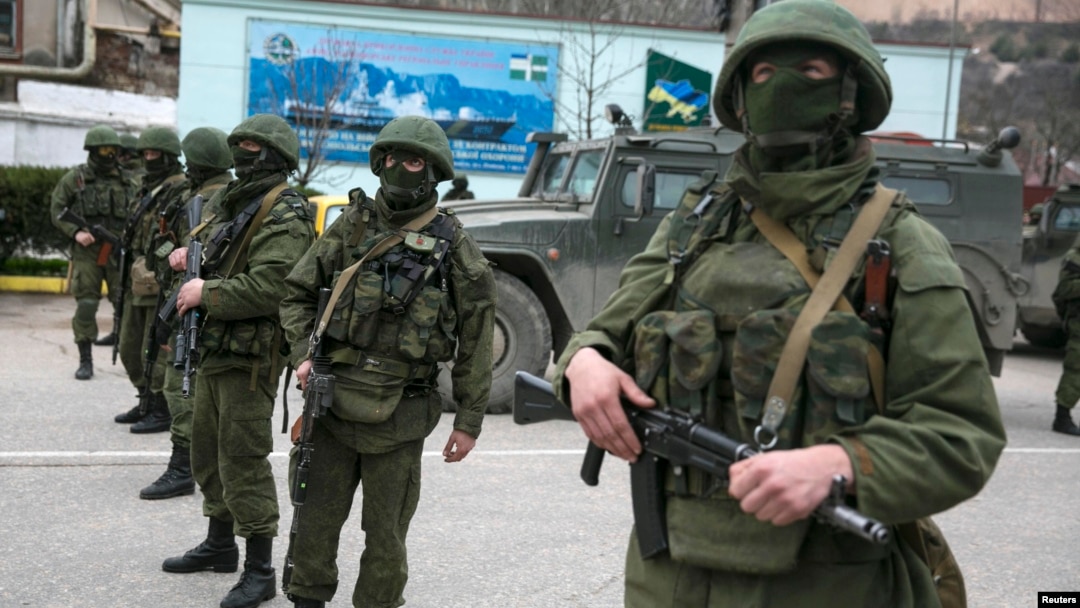 Armed servicemen stand near Russian Army vehicles outside a Ukrainian border-guard post in the Crimean town of Balaclava.