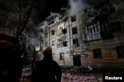 Пожарникари пред жилищна сграда в Харков, ударена от руски дрон, 24 януари 2026 г.