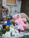 Люди несуть іграшки та ставлять лампадки біля зруйнованого російським ударом будинку. Київ, 3 липня 2026 року