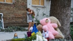 Люди несуть іграшки та ставлять лампадки біля зруйнованого російським ударом будинку. Київ, 3 липня 2026 року