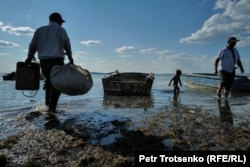 Locals prepare for a fishing run on the shore of the Aral Sea.