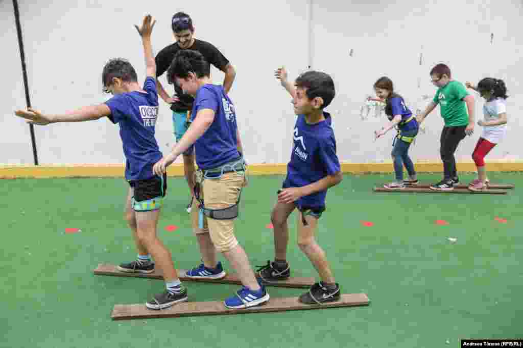 Copii cu diverse deficiențe se joacă în timpul unei petreceri organizate de Climb Again la Școala Gimnazială Specială pentru Deficienți de Vedere din București.