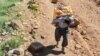 Kolbar -- transborder porter who is employed to carry goods on their backs across the Iran-Iraq border -- carrying his load across western Iranian mountains.