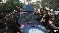 Police escort an armored vehicle carrying arrested bodyguard Malik Mumtaz Hussain Qadri, the alleged killer of Punjab Governor Salman Taseer in Rawalpindi on January 6.