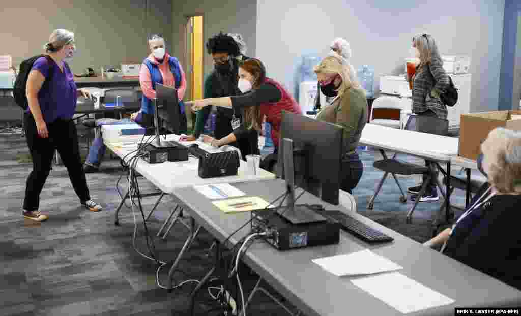 В Декейтер, штате Джорджия, работники офиса регистрации и выборов проверяют бюллетени заочного голосования