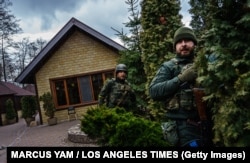 Yaroslav Amosov (center) and another member of Ukraine’s territorial defense forces react to incoming artillery fire in Irpin on March 6, 2022.