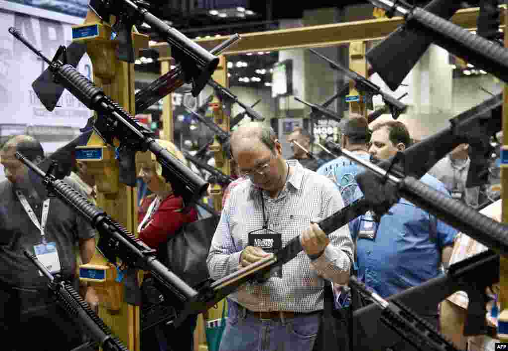 A convention goer inspects a rife in the exhibition hall at the 143rd National Rife Association (NRA) Annual Meetings and Exhibits at the Indiana Convention Center in Indianapolis, Indiana. (AFP/Karen Bleier)