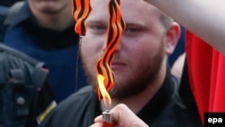 Ukrainian nationalists burn a St. George ribbon during the Victory Day celebrations, marking the anniversary of the victory over Nazi Germany in World War II, in Kyiv on May 9.