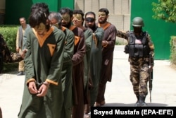 Afghan security officials present arrested members of the Taliban on the outskirts of Ghazni on May 29.