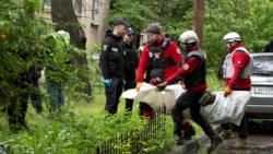 Рятувальники несуть тіло загиблого внаслідок удару російської атаки на Київ, 7 травня 2025 року