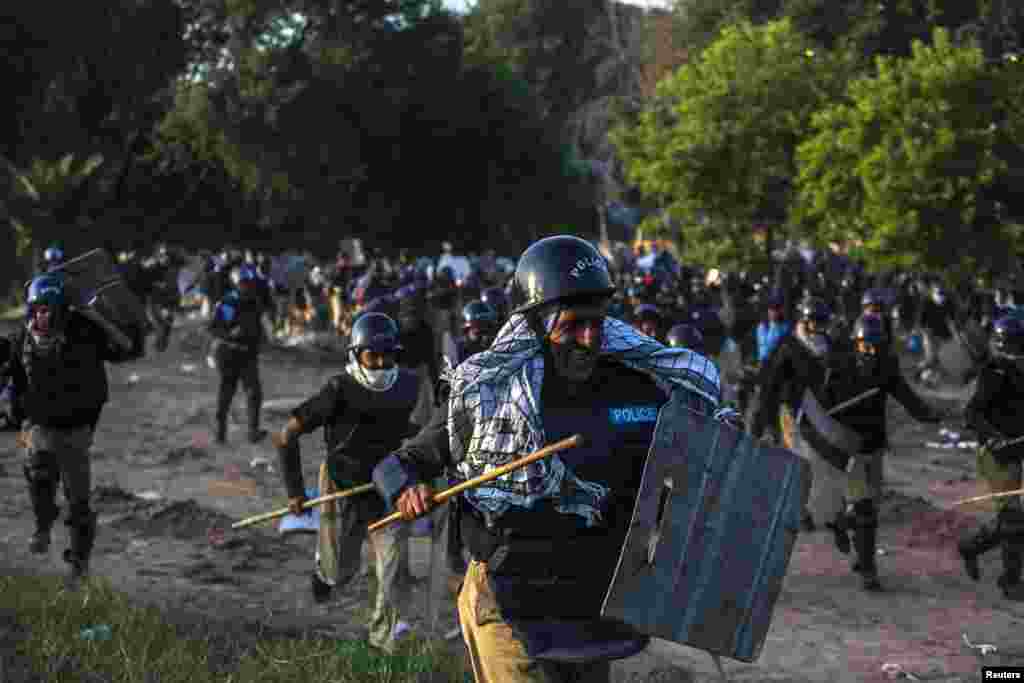 Riot police run away from supporters of Tahir ul-Qadri, a Sufi cleric and leader of the political party Pakistan Awami Tehreek (PAT), during a protest march in Islamabad on August 31. (Reuters/Akhtar Soomro)