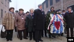 Former prisoners bring candles and flowers to the Death Wall to mark the 72nd anniversary of the liberation of the former Nazi concentration camps at Auschwitz and Birkenau in Oswiecim, Poland, on January 27.