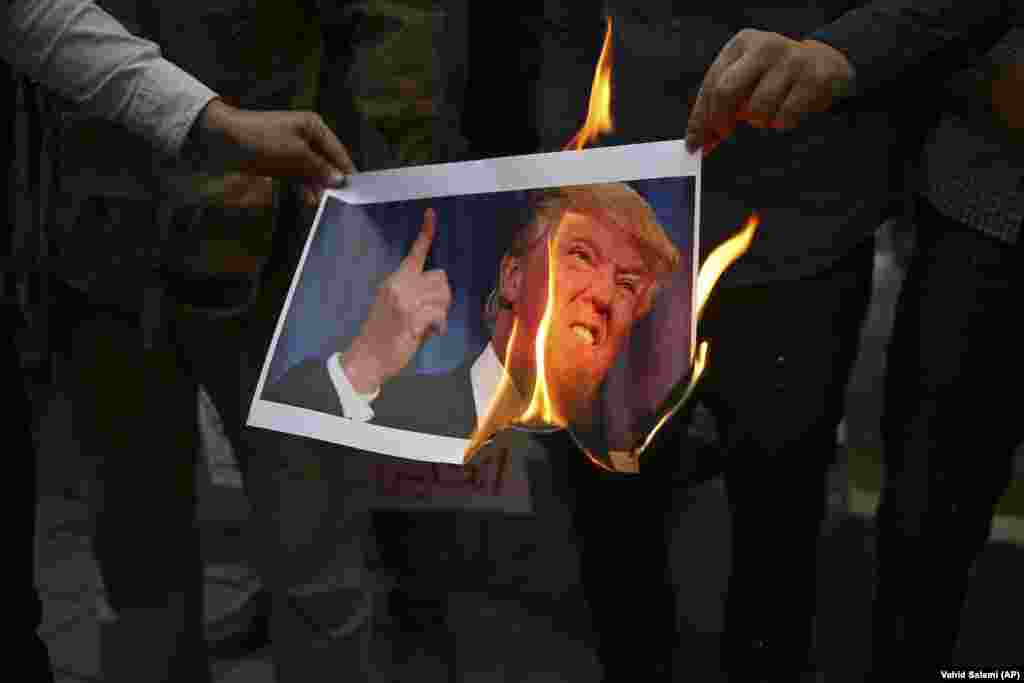 Iranian demonstrators burn a picture of U.S. President Donald Trump during during a protest in front of the former U.S. Embassy in response to Trump&#39;s decision to pull out of the nuclear deal and renew sanctions. (AP/Vahid Salemi)