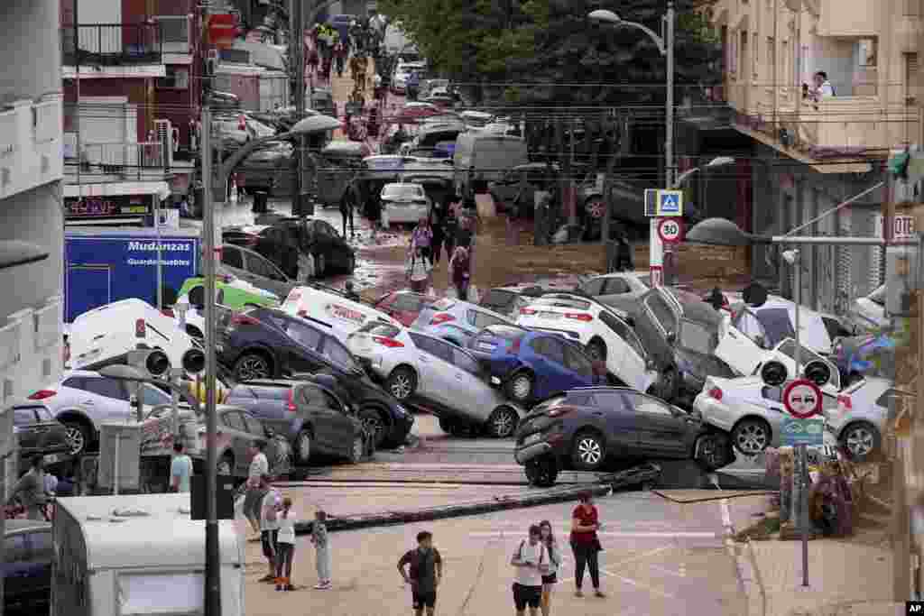 Ljudi stoje pored automobila koje su na gomilu navukle velike poplave, Alfafar, 1. novembra 2024. Uništene su zgrade i infrastruktura, ogroman broj automobila gomila se na ulicama, a veliki broj puteva je zatvoren.