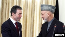 NATO Secretary-General Anders Fogh Rasmussen (left) shakes hands with Afghan President Hamid Karzai during a meeting at the presidential palace in Kabul last year.