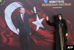 Женщина позирует для фото на фоне плаката с изображением Реджепа Эрдогана. Анкара, 2 августа 2016 года