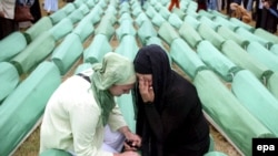 Bosnian Muslim women mourn over a casket during the funeral of 465 Bosnian Muslims at the Potocari Memorial Center in 2007.