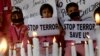 Индийские школьники в городе Силигури держат плакаты "Остановить террор" на акции в память об убитых учащихся школы в Пешаваре