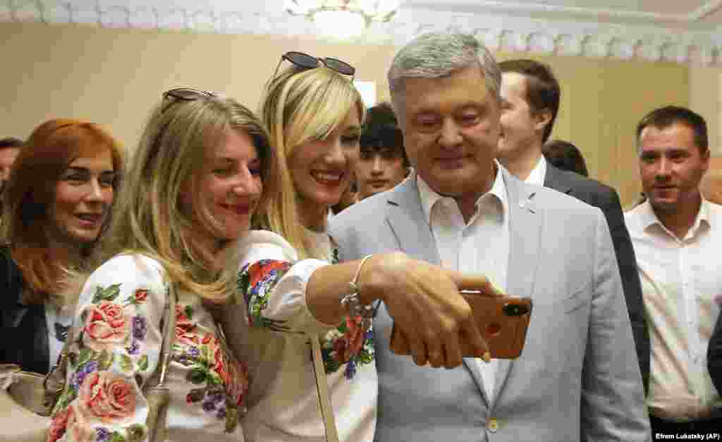Former Ukrainian President Petro Poroshenko poses for a selfie with voters as he visits a polling station to cast his vote in Kyiv. Poroshenko, who is allied with the European Solidarity party, was defeated by Volodymyr Zelenskiy in April's presidential vote. (AP/Efrem Lukatsky)