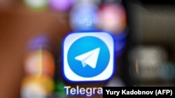 RUSSIA -- An illustration picture taken through a magnifying glass shows the icon of the popular messaging app Telegram on a smart phone screen - generic