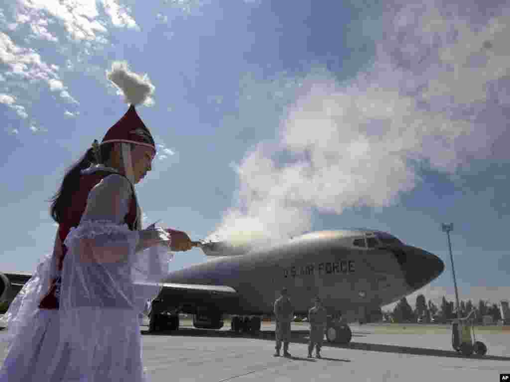 A Kyrgyz woman at Manas International Airport performs a traditional ritual during a ceremony to mark the opening of a new U.S. Army aircraft ramp on June 23. Photo by for Vladimir Voronin for AP