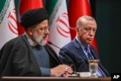 Turkish President Recep Tayyip Erdogan (right) listens to Iranian President Ebrahim Raisi during a joint news conference following their meeting at the presidential palace in Ankara, Turkey, on January 24.