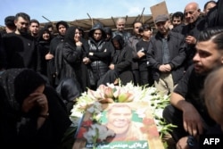 Iranians mourn at a funeral for loved ones killed in recent air strikes, at the Behesht Zahra cemetery in southern Tehran on March 26.